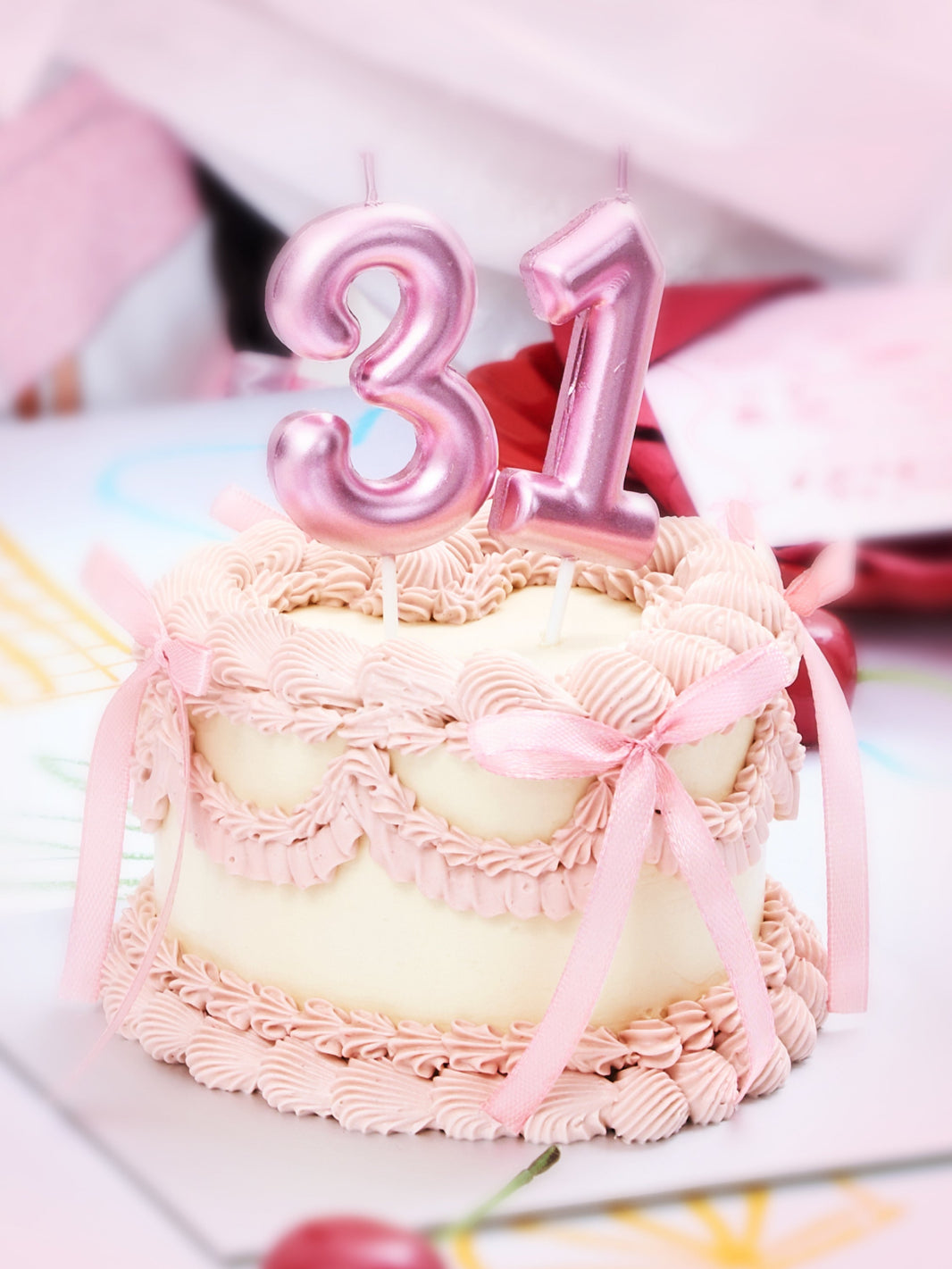 Pink frosted cake with “31” candles celebrating prettyFIT 31st anniversary.